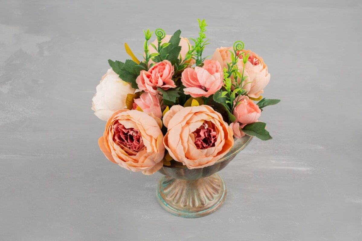 A beautiful flower presentation of pink roses in a stylish vase, placed on a table.