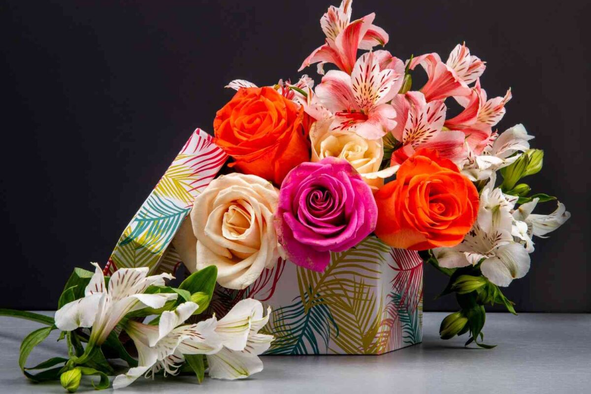 A side view of colorful flowers with gifts placed on a table.