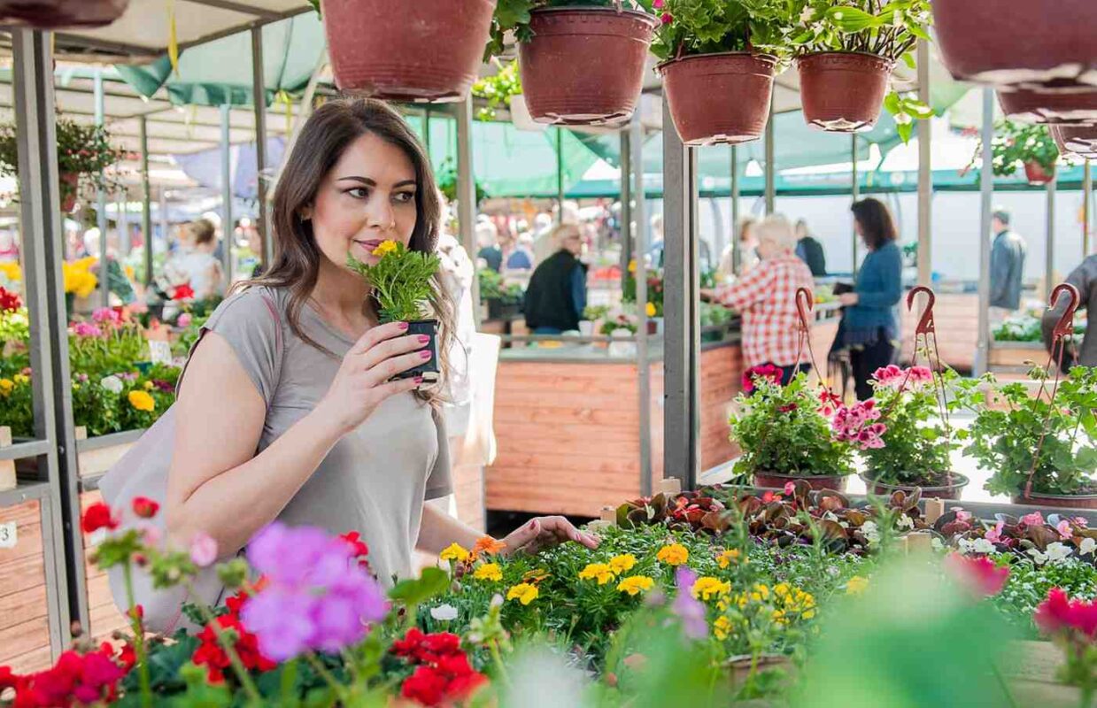 A young woman smelling the fragrance of flowers in a flower shop.