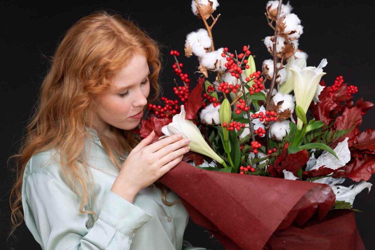 A medium shot of a woman smelling a large bunch of prettiest flowers.