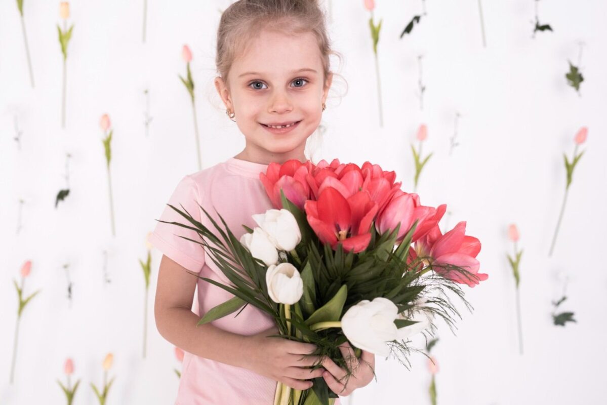 A happy little girl holding a pretty flower bouquet